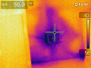 Thermal imaging of a wall outlet reveals a cold area around the outlet, reaching down to 50 degrees (F), while areas around reach up to 63 degrees (F).