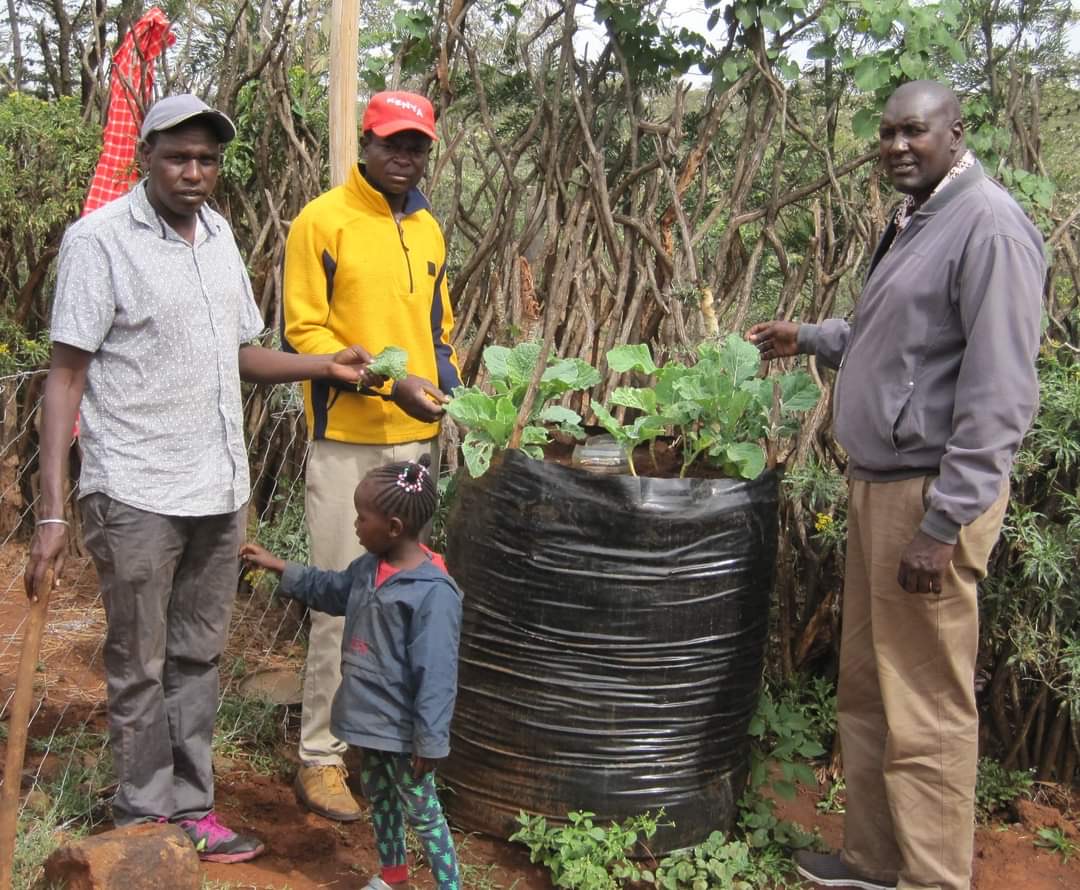 Joel Lankas (left) stands by a sack garden at his home along with his daughter Ester and friends Cris Meja and Douglas Khamala. Photo contributed by Joel Lankas.